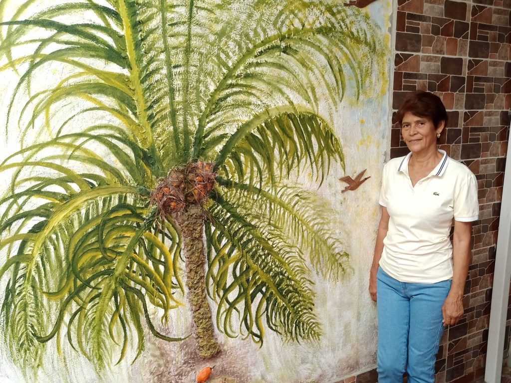 Además de ser palmicultora, Dineth estudió artes plásticas en la Universidad de La Sabana. Aquí aparece al lado de un mural de su autoría